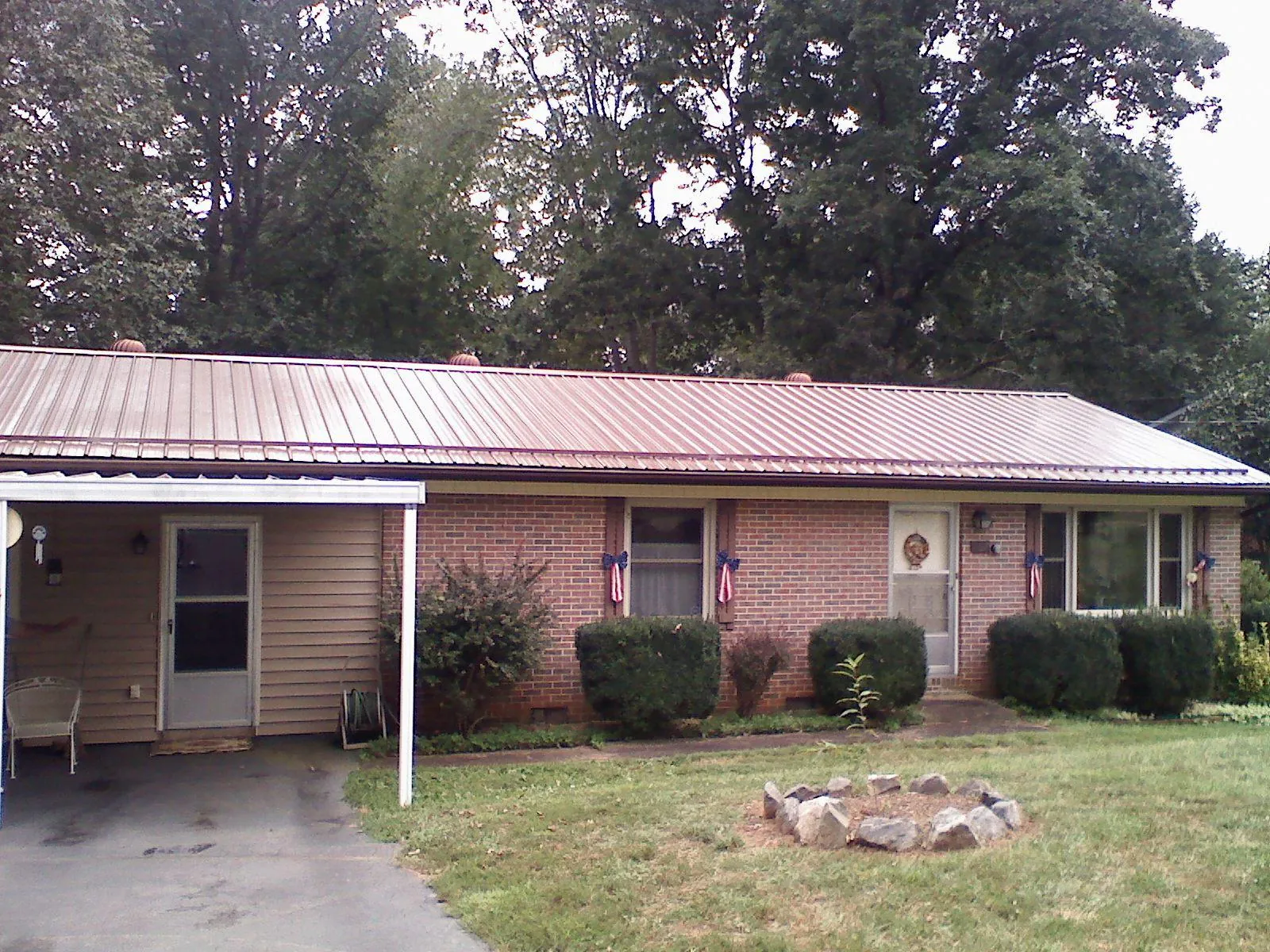 Bronze metal roof and carport on a brick ranch home — Roof Repair work by our crew in Clio